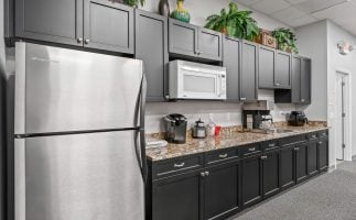 A modern kitchen featuring sleek black cabinets and shiny stainless steel appliances.