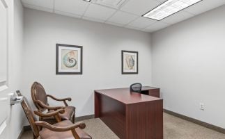 A tidy office featuring a desk and chair, emphasizing a clean and organized workspace.
