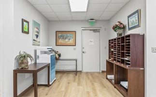 A hallway featuring a desk with a printer positioned beside it, creating a functional workspace.