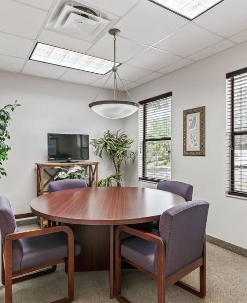 A conference room featuring a large table surrounded by several chairs, designed for meetings and discussions.