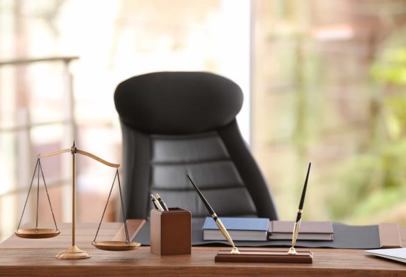 A professional law office desk featuring a gold scale of justice, pens, and books, symbolizing legal services in Central Florida attorneys conduct depositions.